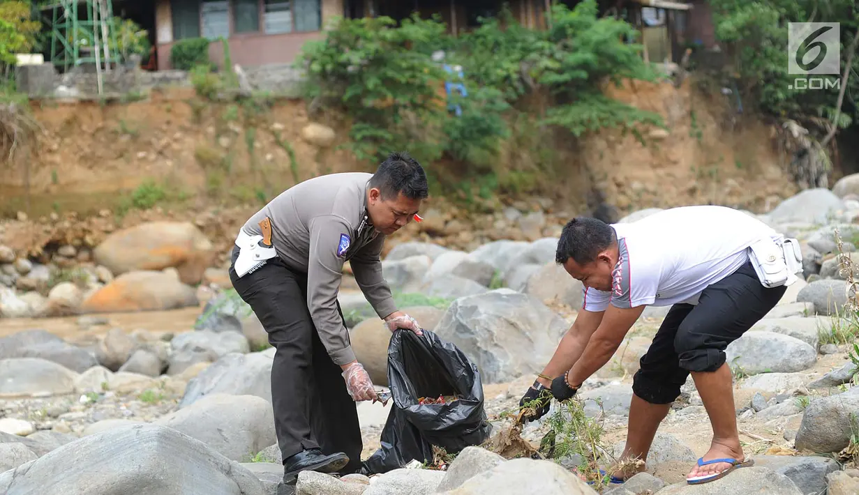 Dua Anggota Polantas Polres Bogor memungut sampah saat kegiatan aksi bersih sungai di kawasan aliran Sungai Ciliwung, gadog, Bogor (20/9). (Merdeka.com/Arie Basuki)