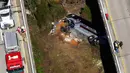 Sebuah bus carteran jatuh setelah menabrak pembatas di Loxley, Alabama (13/3). Bus tersebut membawa anggota band SMA di Texas pulang dari Disney World. (AP Photo / Dan Anderson)