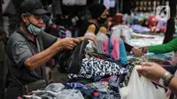 Seorang pedagang menggunakan kantong plastik di Kawasan Pasar Jatinegara, Jakarta, Selasa (30/6/2020). Mulai 1 Juli 2020 penggunaan kantong plastik sekali pakai dilarang di mal, toko swalayan, dan pasar tradisional di DKI Jakarta. (Liputan6.com/Faizal Fanani)