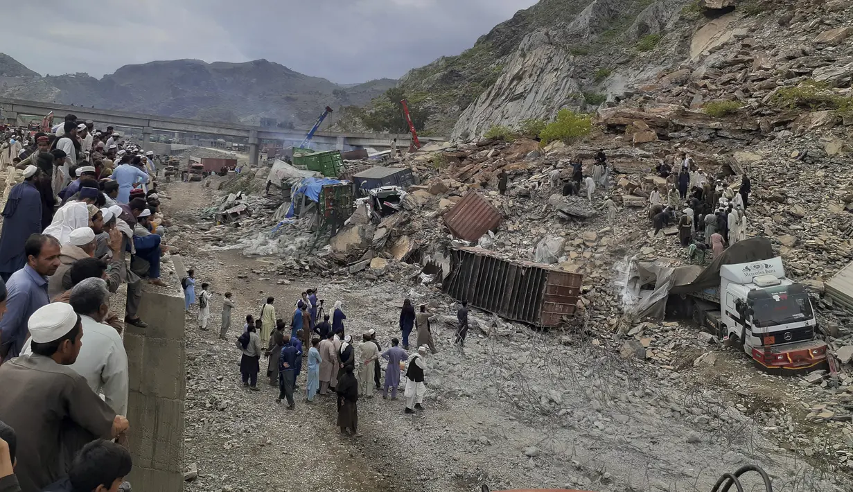 Pejabat polisi Ishrat Khan mengatakan puluhan petugas pemadam kebakaran dan tim penyelamat berusaha menyelamatkan para pengemudi truk dan orang-orang lain yang tertimbun tanah longsor di dekat perbatasan Afghanistan. (AP Photo/Muhammad Sajjad)