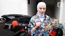 Aktris Angel Lelga turun dari kendaraannya di kediamannya di kawasan Jagakarsa, Jakarta, Rabu (6/7/2022). Meski baru mengenakan hijab sejak beberapa tahun lalu, gaya hijab Angel Lelga tergolong unik karena memilih model hijab era tahun 1980-an yang dimodifikasinya dengan gaya modern. (Liputan6.com/Herman Zakharia)