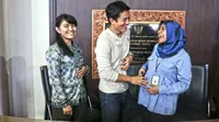 Pebalap Nasional, Rio Haryanto saat mengelus perut seorang ibu, yang sedang hamil saat foto bersama di Bandara Soekarno-Hatta, Cengkareng, Tangerang, Rabu (2/11/2015). (Bola.com/Nicklas Hanoatubun)