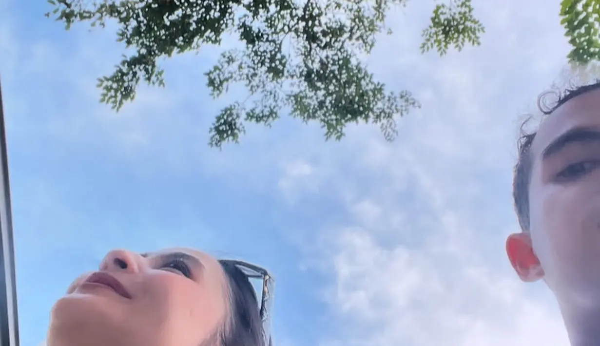 Bersama Omar, Prilly tampil mengenakan atasan halter neck baby blue dnegan gaya rambut cepol messynya. [@prillylatuconsina96]