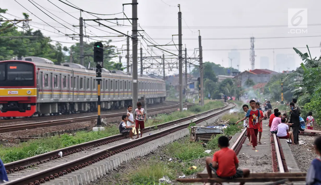 Anak-anak bermain layang-layang di rel kereta api kawasan Jakarta Timur, Kamis (3/1). Minimnya lahan terbuka hijau memaksa anak-anak setempat memilih kawasan rel kereta api sebagai lokasi bermain. (Merdeka.com/Iqbal Nugroho)