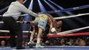  Floyd Mayweather Jr. di dorong ke tali ring oleh Marcos Maidana saat bertarung memperebutkan gelar juara dunia kelas Welter Super WBA. 3 Mei 2014.(AFP)