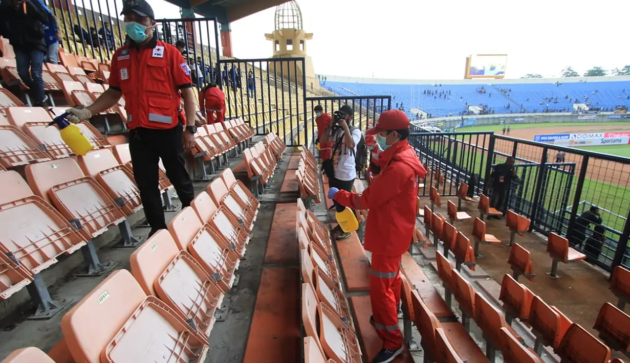 Petugas melakukan penyemprotan disinfektan di seluruh tribun stadion Si Jalak Harupat, Bandung, Minggu (15/3/2020). Hal tersebut dilakukan untuk mencegah penyebaran virus corona. (Bola.com/Erwin Snaz)