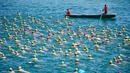 Dua orang di atas perahu mengawasi para peserta dalam perhelatan tahunan menyeberangi Danau Zurich di Swiss, 5 Juli 2017. Dalam ajang tersebut, ratusan peserta harus bersaing mengarungi Danau Zurich sejauh 1,5 kilometer. (AFP PHOTO / Michael Buholzer)