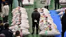 Pedagang grosir memeriksa kualitas tuna beku menjelang tradisi lelang Tahun Baru di Pasar ikan Toyosu, Tokyo, Minggu (5/1/2020). Lelang ikan ini adalah kegiatan rutin usai Tahun Baru yang biasanya diadakan menjelang fajar di pasar ikan Toyosu. (Kazuhiro NOGI / AFP)