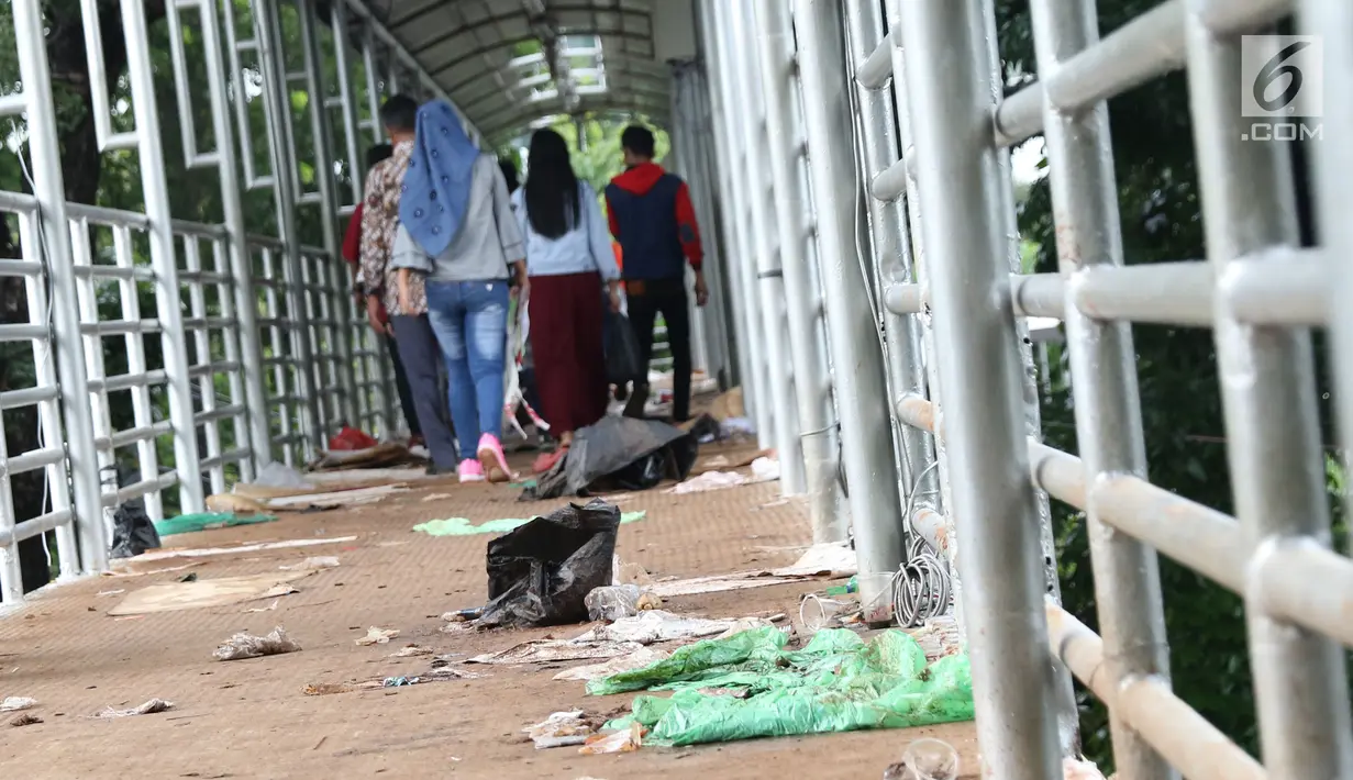 Sampah berserakan di koridor Jembatan Penyebrangan Orang (JPO) Jalan Medan Merdeka Barat, Jakarta, Selasa (1/1). Hal ini mengganggu kenyamanan warga yang melintas di JPO Medan Merdeka Barat. (Liputan6.com/Helmi Fithriansyah)