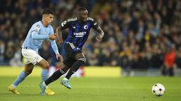 Bek Manchester City Joao Cancelo berebut bola dengan penyerang Copenhagen  Mohamed Daramy dalam matchday ketiga Grup G Liga Champions 2022/2023 di Etihad Stadium, Kamis (6/10/2022) dini hari WIB. Manchester City menang besar atas FC Copenhagen dengan skor telak 5-0. (AP Photo/Dave Thompson)