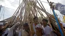 Peserta menyusun kayu membentuk puncak kerucut saat ritual Mekotek di Bali (11/11). Dalam ritual Mekotek, para peserta mengadu tongkat dalam kelompok yang berisi 20-30 orang. (AP Photo/Firdia Lisnawati)