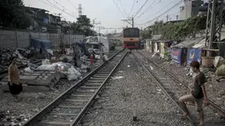 Selain mengganggu lalu lintas kereta, bangunan kumuh di bantaran rel kereta api ini pun membahayakan penghuni jika kereta melintasi kawasan tersebut, Jakarta, (26/9/14). (Liputan6.com/Faizal Fanani)