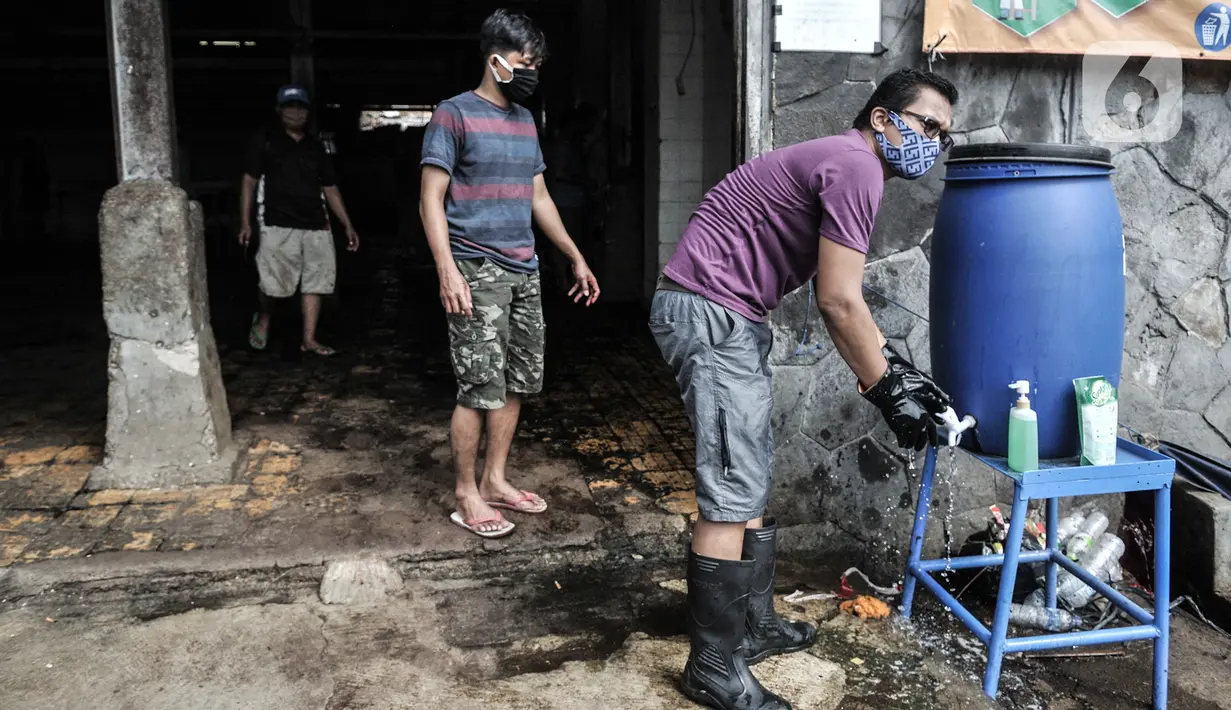 Petugas mencuci tangan saat keluar masuk area penyembelihan hewan kurban Idul Adha di RPH Pulogadung, Jakarta, Jumat (31/7/2020). RPH Pulogadung menyembelih 50 sapi dan puluhan kambing dengan proses pemotongan sesuai syariat Islam dan protokol kesehatan COVID-19. (merdeka.com/Iqbal S. Nugroho)