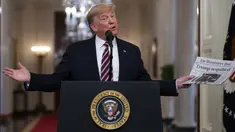 Presiden Donald Trump mengangkat sebuah surat kabar dengan tajuk utama bertuliskan "Trump dibebaskan" selama acara perayaan kemenangan, satu hari setelah upaya pemakzulannya dibatalkan di Ruang Timur Gedung Putih, Washington (6/2/2020). (AP Photo/Evan Vucci)