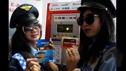 Dua orang Pramuniaga menunjukan beberapa kartu E-money yang dapat digunakan untuk pembayaran parkir di Terminal Parkir Elektronik (TPE), Jakarta, Kamis (29-01-2015). Sebanyak enam bank terlibat dalam sistem pembayaran ini. (Liputan6.com/Andrian M Tunay)