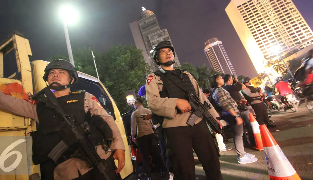 Petugas kepolisian bersenjata lengkap berjaga di kawasan Bundaran HI, Jakarta, Sabtu (31/12). Untuk mengamankan jalannya perayaan malam tahun baru, Polda Metro Jaya menempatkan personelnya di sejumlah sudut Ibu Kota. (Liputan6.com/Immanuel Antonius)