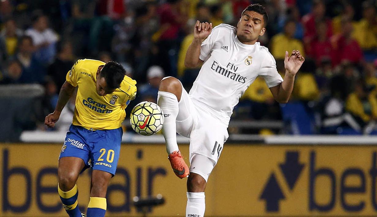 Gelandang Real Madrid, Casemiro, berebut bola dengan gelandang Las Palmas, Jonathan Viera. Kemenangan Real Madrid ditentukan oleh gol Casemiro pada satu menit sebelum laga usai. (Reuters/Juan Medina)