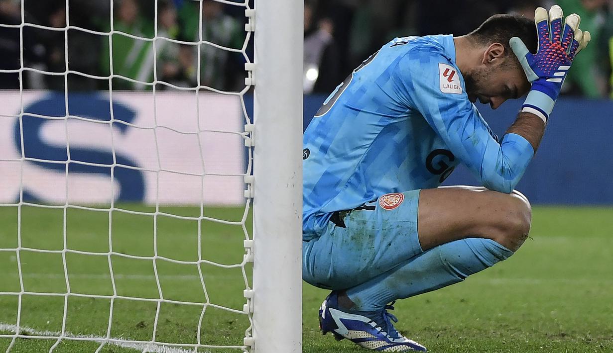 Reaksi kecewa kiper Girona, Paulo Gazzaniga setelah gawangnya dibobol oleh pemain Real Betis, German Pezzella pada laga pekan ke-18 Liga Spanyol 2023/2024 di Benito Villamarin Stadium, Sevilla, Spanyol, Jumat (22/12/2023) dini hari WIB. (AFP/Cristina Quicler)