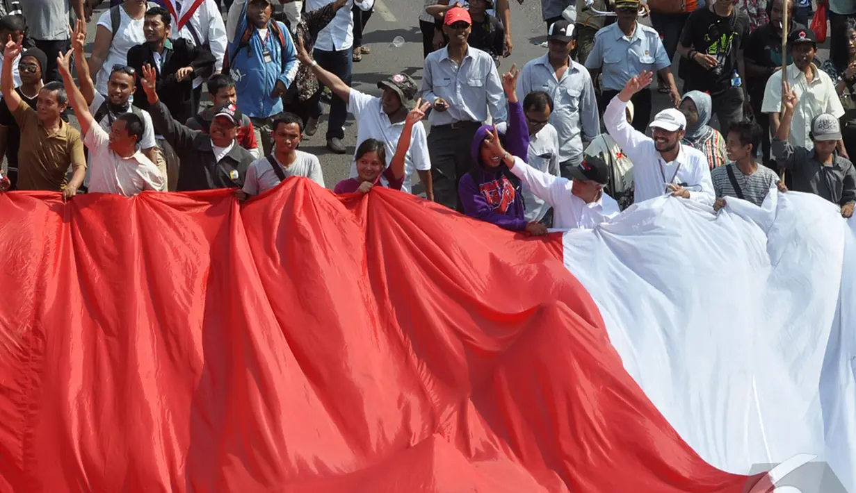 Pelantikan Jokowi menjadi Presiden RI ke-7 disambut gegap gempita. Bendera raksasa dibentangkan mengiringi Jokowi ke Istana Merdeka, Jakarta, Senin (20/10/2014) (Liputan6.com/Miftahul Hayat)