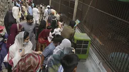 Keluarga mengunjungi kebun binatang di titik piknik untuk merayakan liburan Idul Fitri, membuat di akhir bulan puasa Ramadhan, di Lahore, Pakistan, Rabu, 4 Mei 2022. (AP Photo/K.M. Chaudary)