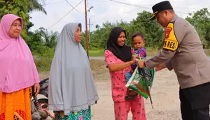 Kapolres Rokan Hilir AKBP Isa Imam Syahroni memberikan bantuan kepada ibu rumah tangga. (Liputan6.com/M Syukur)