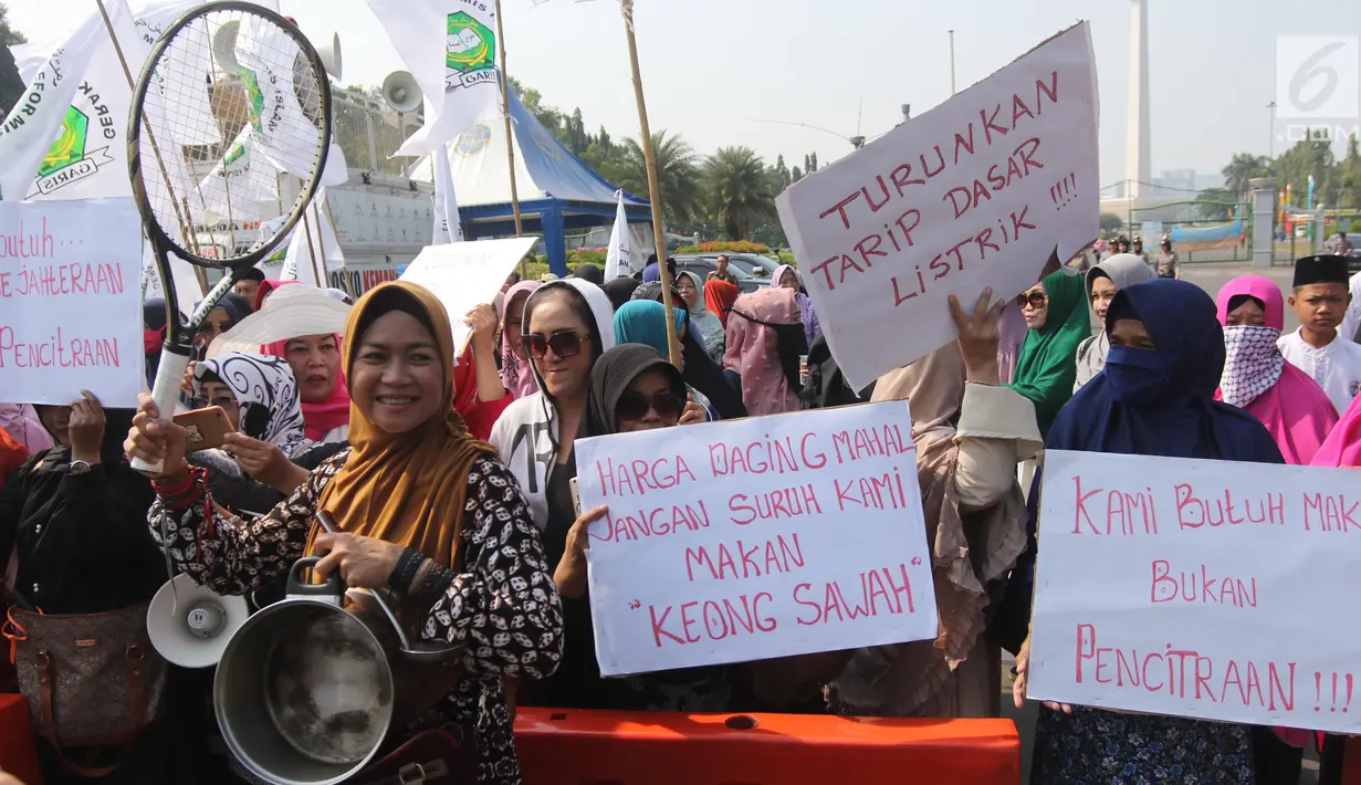 Sejumlah ibu-ibu yang tergabung dalam Barisan Emak-Emak Militan (BE2M) Indonesia menggelar aksi di seberang Istana Merdeka, Jakarta, Rabu (18/7). Mereka menuntut Presiden Jokowi menurunkan harga sembilan bahan pokok (sembako). (Liputan6.com/Arya Manggala)