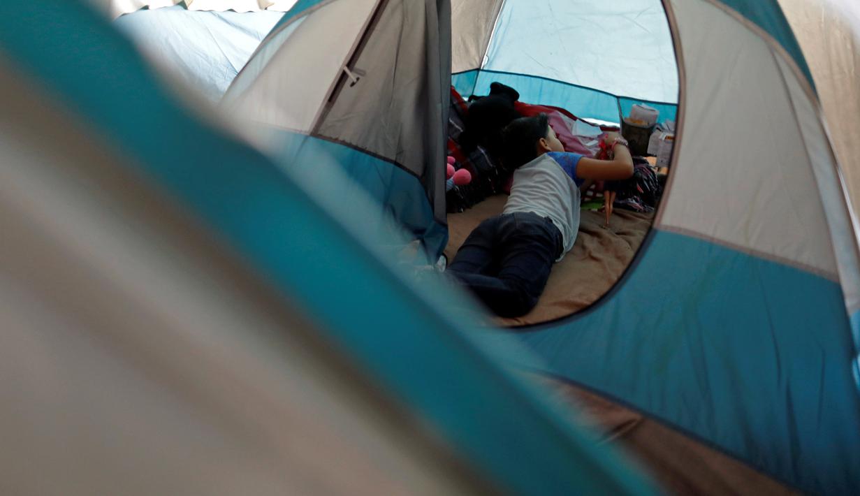 Seorang anak imigran bermain di dalam tenda tempat penampungan di Tijuana, Meksiko 6 April 2019. Rombongan migran Amerika Tengah mencapai kota perbatasan antara Meksiko dan AS tersebut  untuk mencari suaka akibat kekerasan, pembunuhan dan kemiskinan yang mengancam mereka. (REUTERS/Carlos Jasso)