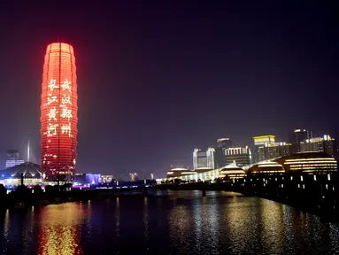 Sebuah bangunan memancarkan sejumlah slogan sebagai penghormatan bagi orang-orang yang berjuang melawan virus corona COVID-19 di Zhengzhou, Provinsi Henan, China, Sabtu (21/3/2020). Wabah COVID-19 di China saat ini sudah mulai mereda. (Xinhua/Zhu Xiang)