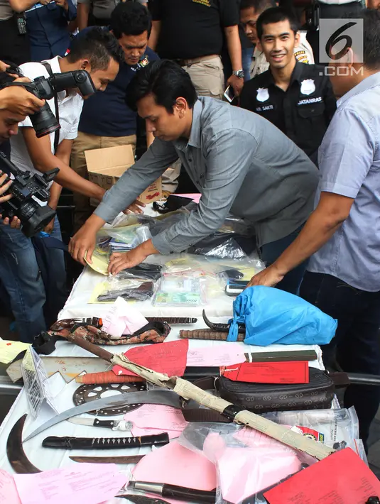 Petugas menata barang bukti kejahatan saat rilis hasil operasi cipta kondisi Ramadan di Polda Metro Jaya, Jakarta, Rabu (21/6). Puluhan preman terjaring operasi cipta kondisi yang dilakukan serentak di wilayah di DKI Jakarta. (Liputan6.com/Angga Yuniar)