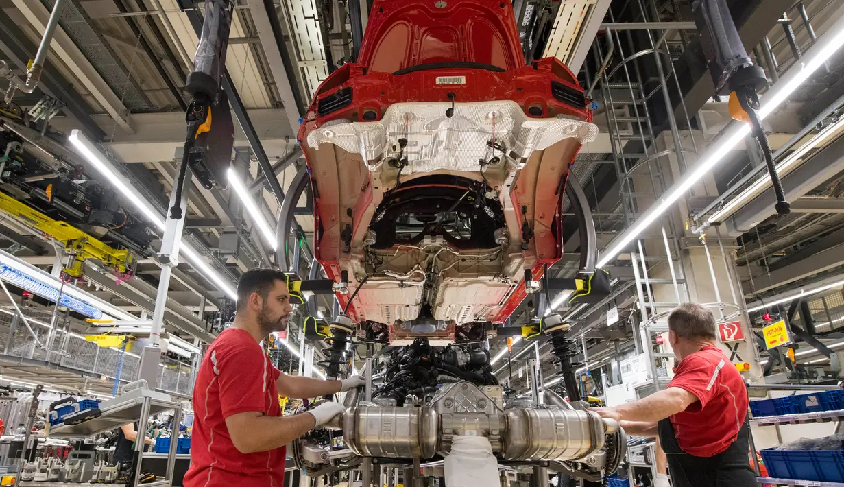 Karyawan bekerja merakit bagian mesin mobil Porsche di pabrik Porsche di Stuttgart, Jerman (26/1). Yang unik nilai besaran bonus itu diambil dari merk mobil sport Porsche paling populer, 911. (AFP Photo/Thomas Kienzle)