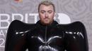 Sam Smith berpose untuk fotografer setibanya pada karpet merah Brit Awards 2023 di London, Sabtu (11/2/2023). Pelantun ‘Unholy’ ini memakai gaun unik berwarna hitam, lengkap dengan sepatu heels dan sarung tangan berwarna senada. (Photo by Vianney Le Caer/Invision/AP)