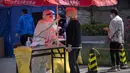 <p>Seorang pekerja yang mengenakan alat pelindung diri menyeka tenggorokan seorang pria saat tes COVID-19 di tempat pengujian setelah pihak berwenang memerintahkan putaran ketiga dari tiga tes COVID-19 berturut-turut untuk penduduk di Distrik Chaoyang, Beijing, China, Sabtu (7/5/2022). (AP Photo/Mark Schiefelbein)</p>