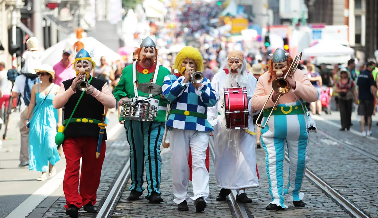 Sejumlah seniman mengenakan kostum sambil memainkan alat musik selama perayaan Hari Nasional Belgia di Brussels, Kamis (21/7). Belgia dalam status waspada sejak tragedi Bom Brussels yang menewaskan 34 orang pada 22 Maret 2016 lalu. (Foto: Arie Asona)