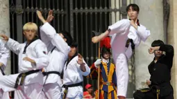 Atlet Taekwondo dari Korea Selatan melakukan gerakan saat tampil di depan Paus Fransiskus saat pertemuan umum mingguan di Lapangan Santo Petrus, Vatikan (30/5). (AP Photo/Gregorio Borgia)