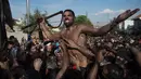 Peserta berlumuran oli saat mengikuti Festival Cascamorras di Baza, Granada, Spanyol, Kamis (6/9). Festival tradisional ini berlangsung setiap tanggal 6 September. (JORGE GUERRERO/AFP)