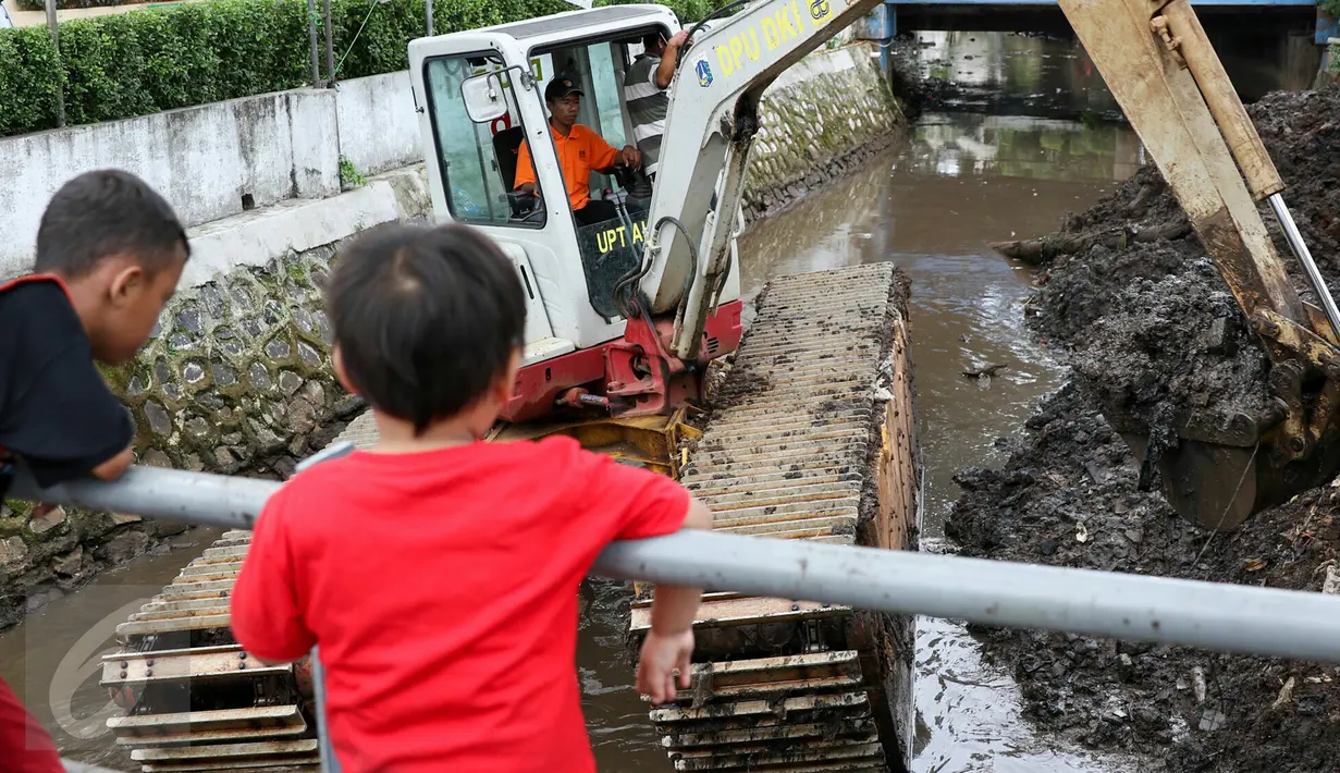 Anak-anak menonton pengerukan lumpur di Kali Baru Barat di jalan Dr Saharjo, Menteng Atas, Jakarta, Selasa (23/2). Sudin Tata Air Jakarta Selatan menurunkan 1 alat berat untuk melakukan pengerukan sendimen lumpur. (Liputan6.com/Yoppy Renato)
