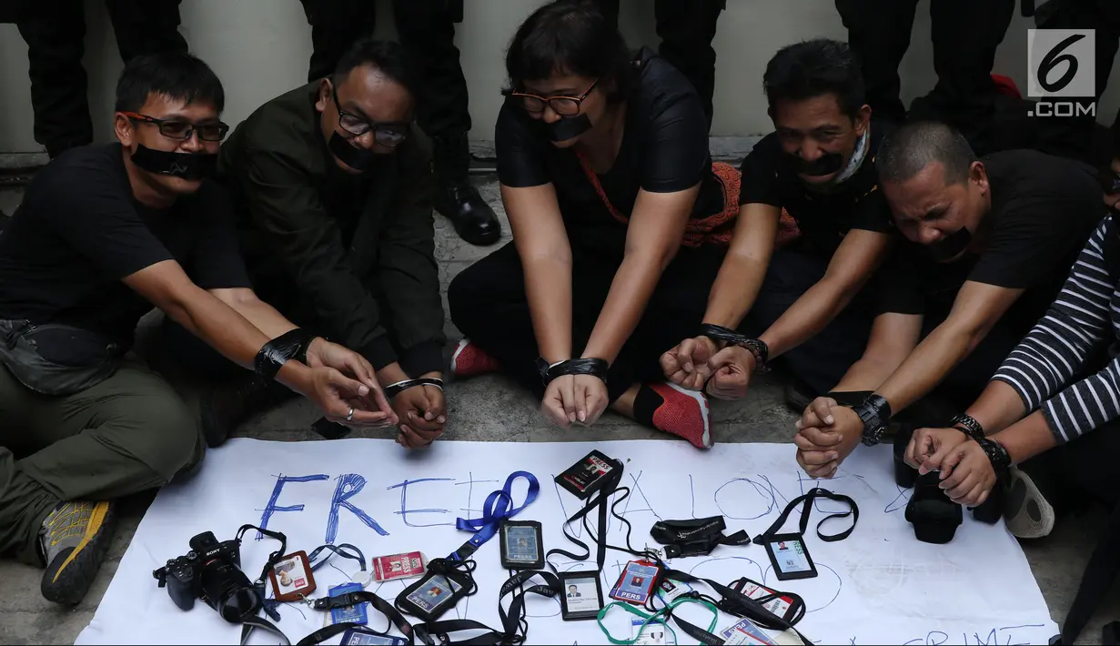 Jurnalis mengikat tangan dan menutup mulut di depan Kedubes Myanmar, Jakarta, Jumat (7/9). Mereka mendesak pemerintah Myanmar membebaskan Wa Lone dan Kyaw Soe Oo yang menulis laporan serangan militer di Rakhine. (Liputan6.com/Helmi Fithriansyah)