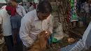 Seorang pembeli memeriksa gigi seekor kambing domba di sebuah pasar di New Delhi, India, (30/8). umat Muslim dari seluruh dunia sedang mempersiapkan menyambut Idul Adha 1438 H. (AP Photo / Manish Swarup)