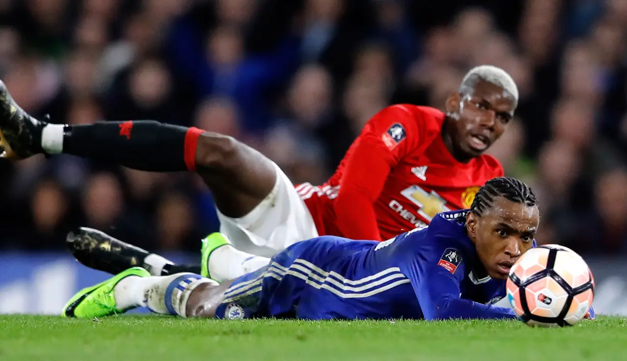 Pemain Manchester United, Paul Pogba dan pemain Chelsea, Willian, terjatuh saat berebut bola dalam perempat final Piala FA di Stadion Stamford Bridge, Senin (13/3). Chelsea lolos ke semifinal Piala FA setelah menang 1-0 atas MU. (AP Photo/Frank Augstein)