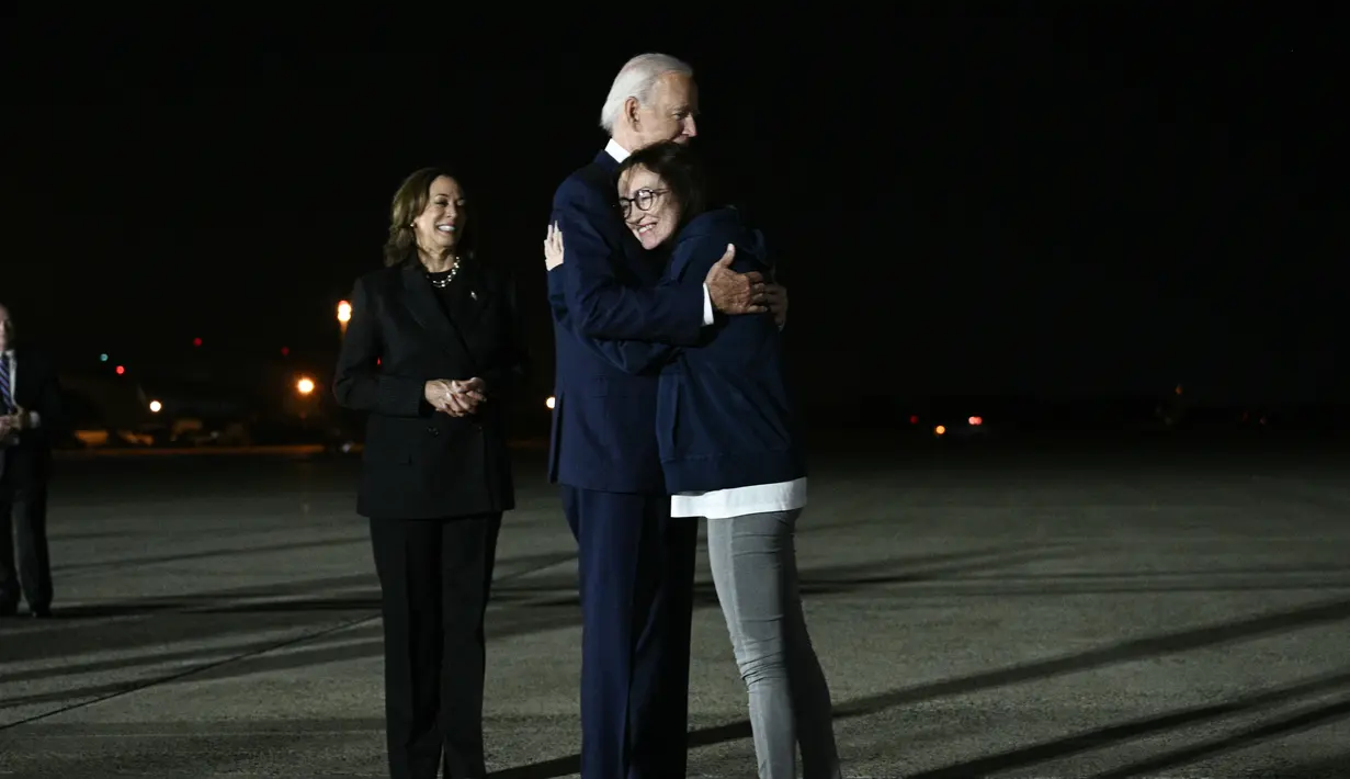 Tiga warga Amerika yang dibebaskan tiba di Pangkalan Angkatan Udara di luar Washington pada larut malam dan disambut oleh keluarga mereka, Presiden Joe Biden dan Wakil Presiden Kamala Harris.  ((Brendan SMIALOWSKI / AFP))