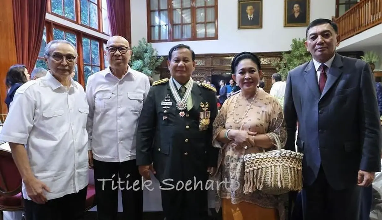 Titiek mengenakan baju kurung coklat bermotif dipadukan rok panjang warna kuning kunyit. Sambil membawa tas jerami anyamannya. [@titieksoeharto]