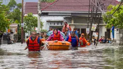 Selain berdampak pada warga, bencana hidrometeorologi yang terjadi ini juga menyebabkan kerusakan infrastruktur dan permukiman. Tampak dalam foto, tim penyelamat mengevakuasi perempuan dan anak-anak dengan perahu karet saat banjir melanda permukiman di Padang, Sumatra Barat, pada 25 November 2025. (Ade Yuandha/AFP)