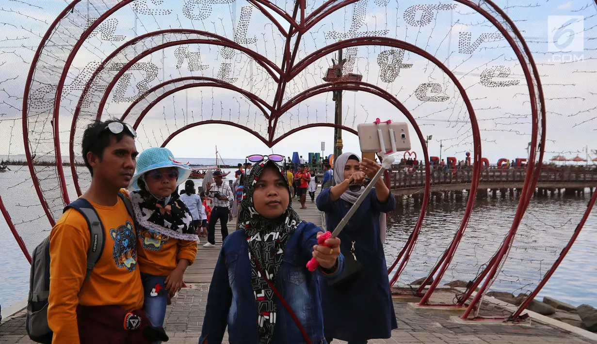 Pengunjung berselfie saat berlibur di berbagai tempat rekreasi di Ancol, Jakarta, Selasa (5/2). Libur Tahun Baru Imlek 2570 ancol masih menjadi tempat wisata pilihan untuk warga Jakarta dan sekitarnya. (Liputan6.com/Johan Tallo)