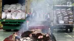 Petugas dari Kementerian Perdagangan memusnakan gula kristal dan daging beku yang sudah kedaluwarsa hasil sitaan dari pasar dengan cara di bakar, di Lapangan Parkir Kemendag, Jakarta Kamis (28/9). (Liputan6.com/JohanTallo)