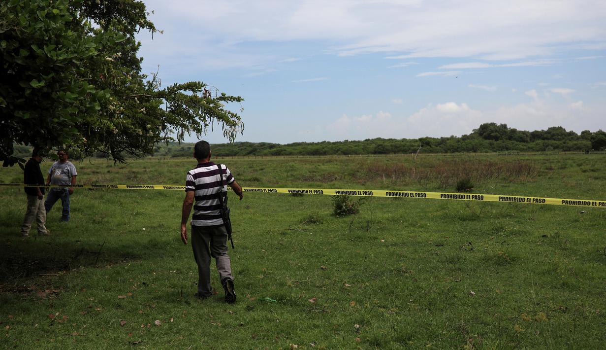 Polisi menutup daerah ditemukannya kuburan massal rahasia di Arbolillo, negara bagian Veracruz, Meksiko, Jumat (7/9). Veracruz merupakan ajang dari pertumpahan darah ketika pertempuran antara kartel narkoba Zetas dan Jalisco berkecamuk. (AP/Felix Marquez)