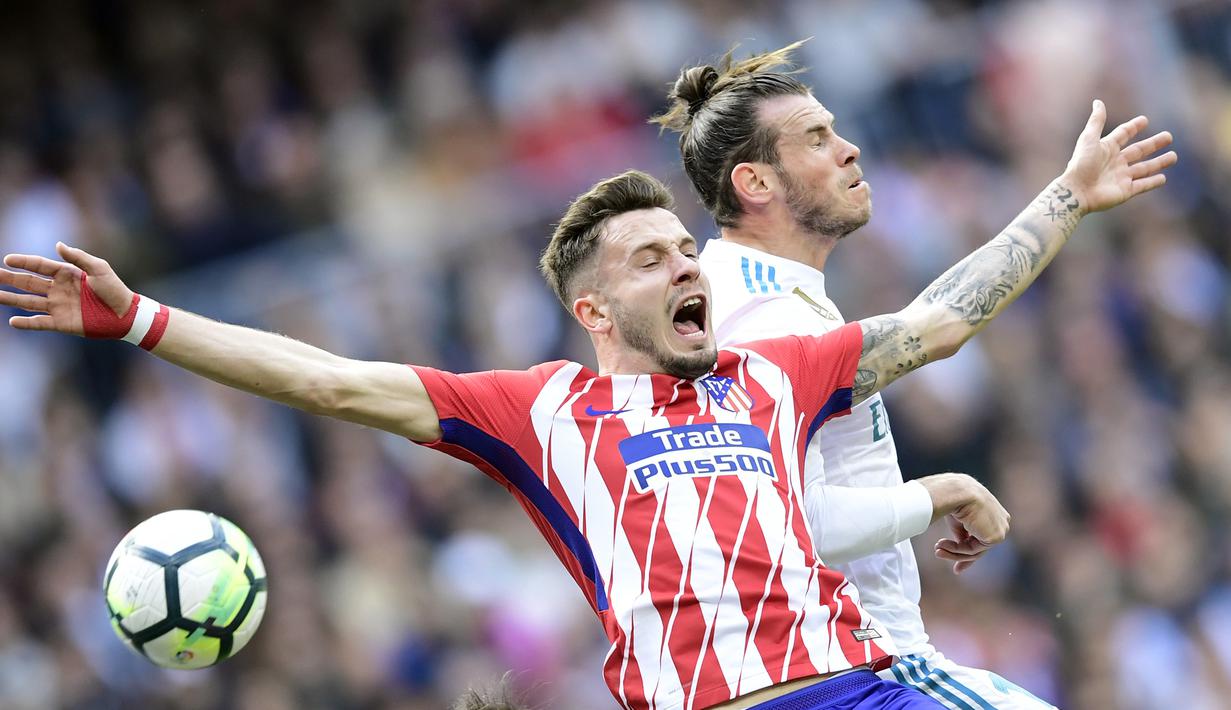Gelandang Real Madrid, Gareth Bale, berebut bola dengan gelandang Atletico Madrid, Saul Niguez, pada laga La Liga Spanyol di Stadion Santiago Bernabeu, Madrid, Minggu (8/4/2018). Kedua klub bermain imbang 1-1. (AFP/Javier Soriano)