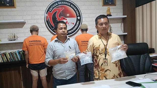 Kasat Narkoba Polresta Pekanbaru Kompol Manapar Situmeang (kanan) bersama alat bukti sabu dan pil ekstasi dari bandar narkoba yang loncat dari kamar hotel berbintang 5.