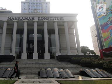 Personil Brimob berjalan melintasi halaman depan Gedung Mahkamah Konstitusi, Jakarta, Kamis (13/6/2019). Mahkamah Konstitusi akan menggelar sidang Perselisihan Hasil Pemilihan Presiden/Wakil Presiden Pemilu 2019 pada, Jumat (14/6). (Liputan6.com/Helmi Fithriansyah)