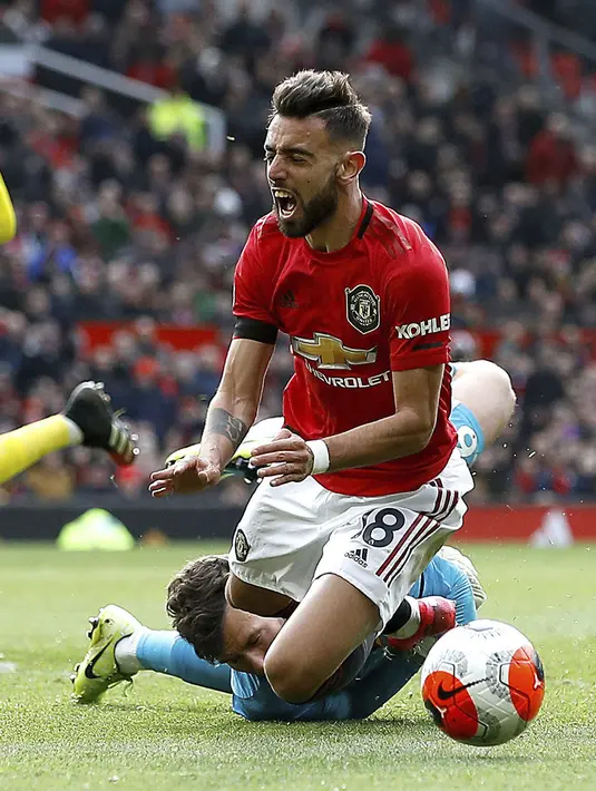 Pemain Manchester United Bruno Fernandes dijatuhkan di area penalti oleh kiper Watford Ben Foster pada pertandingan Liga Inggris di Old Trafford, Manchester, Inggris, Minggu (23/2/2020). Manchester United menang 3-0. (Martin Rickett/PA via AP)