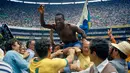 Pemain sepak bola Brasil Edson Arantes do Nascimento atau Pele diangkat di pundak rekan satu timnya setelah mengalahkan Italia dengan skor 4-1 pada final Piala Dunia di Estadio Azteca Mexico City, Meksiko, 21 Juni 1970. Pada tahun 1970, Pele menjadi pemain pertama dan satu-satunya yang memenangkan tiga gelar Piala Dunia, sebagai bagian dari skuad yang dianggap sebagai salah satu tim terhebat dalam sejarah olahraga. (AP Photo, File)